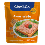 Embalagem laranja tipo stand-up pouch do Atum ralado Chef&Co Food Service. Destaca uma fotografia de torrada coberta com atum ralado e tomate cereja.