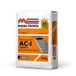 Mockup apresentando quatro embalagens da linha Massa Pronta enfileiradas. Da esquerda para a direita: Argamassa AC-I (embalagem com faixa laranja), Argamassa AC-II (faixa amarela), Argamassa AC-III (faixa azul claro) e Reboco Pronto Premium (faixa verde claro). Todas as sacarias possuem fundo branco na parte superior com o logotipo redesenhado, selo de 30 anos de qualidade, faixas geométricas cinzas e ícones brancos indicando os benefícios de aplicação.