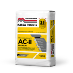 Mockup apresentando quatro embalagens da linha Massa Pronta enfileiradas. Da esquerda para a direita: Argamassa AC-I (embalagem com faixa laranja), Argamassa AC-II (faixa amarela), Argamassa AC-III (faixa azul claro) e Reboco Pronto Premium (faixa verde claro). Todas as sacarias possuem fundo branco na parte superior com o logotipo redesenhado, selo de 30 anos de qualidade, faixas geométricas cinzas e ícones brancos indicando os benefícios de aplicação.