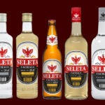 Enfileiramento de cinco garrafas diferentes da Cachaça Seleta, incluindo os formatos de 600ml e 700ml, apresentando os novos rótulos das linhas Prata e Ouro.
