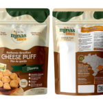 Mockup da embalagem stand-up pouch do pão de queijo Minas Bites linha Gourmet. O painel frontal possui design em tons de verde escuro e bege, com uma janela central transparente em formato de tacho para visualização do produto real, além de uma lista indicando sabores como Queijo em Dobro, Gorgonzola, Goiaba e Alho Poró com Bacon. O verso exibe o mapa do Brasil, instruções de preparo e a história da marca.