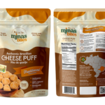 Mockup da embalagem stand-up pouch do pão de queijo Minas Bites sabor Tradicional. O painel frontal apresenta design em tons de marrom e bege, moldura clássica inspirada na arquitetura mineira e a foto de pães de queijo assados dentro de um tacho de cobre. O verso mostra a tabela nutricional, instruções de preparo em inglês e um mapa do Brasil destacando o estado de Minas Gerais.